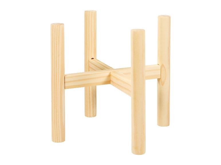 Een houten plantenstandaard met vier poten.