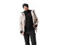 Man in beige ski-jas, zwarte fleece en skibroek met skibril en muts