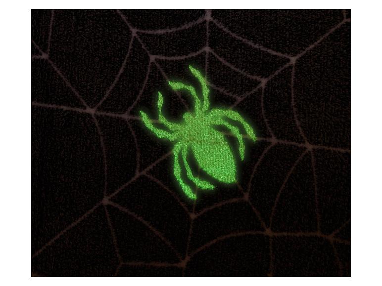 Lichtgevende groene spin op donker spinnenweb, perfect voor Halloween.