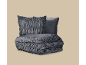 Donkergrijs beddengoedset met geplooide kussens en dekbed.