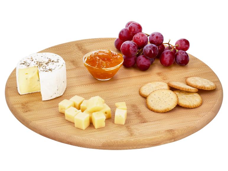 Kaasplank met brie, blokjes kaas, crackers, jam en rode druiven.