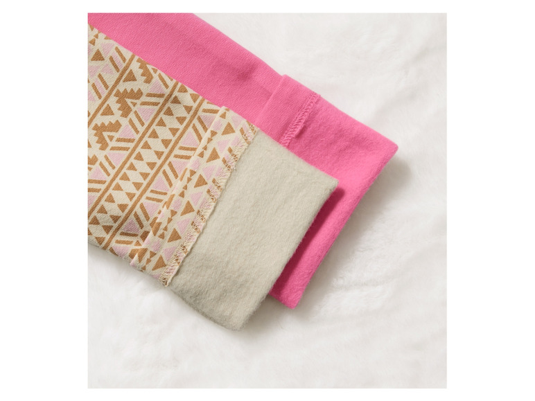 Een roze en beige trui met een geometrisch patroon.