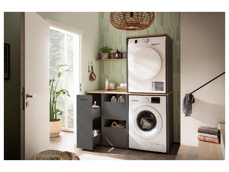 Moderne wasruimte met wasmachine en droger, grijze kasten en groene tegels.