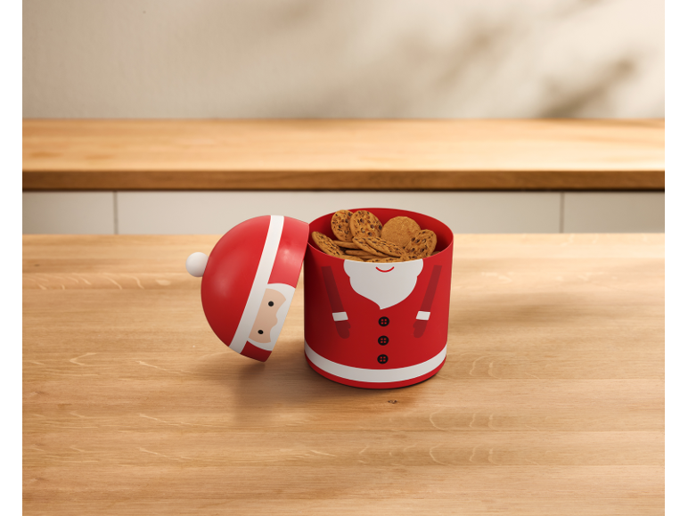 Kerstman-vormige koekjesdoos met koekjes op een houten tafel.