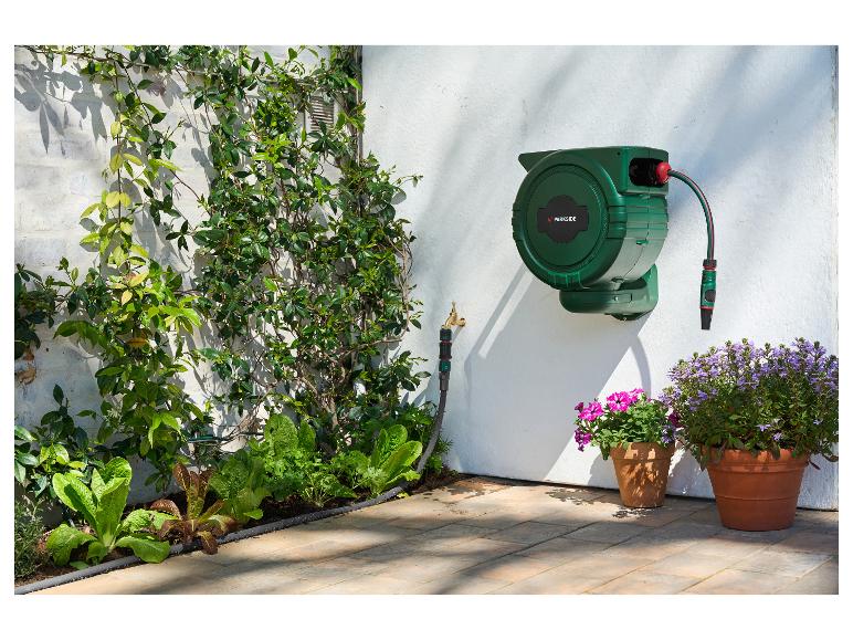 PARKSIDE wandslangbox met automatische oprolfunctie in een tuin met planten.