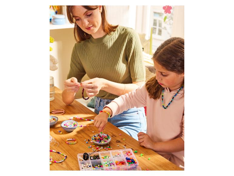 Een moeder en haar dochter maken armbandjes van gekleurde kralen.