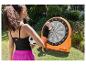 Twee kinderen spelen met een opblaasbaar dartbord en zachte voetballen in een tuin.