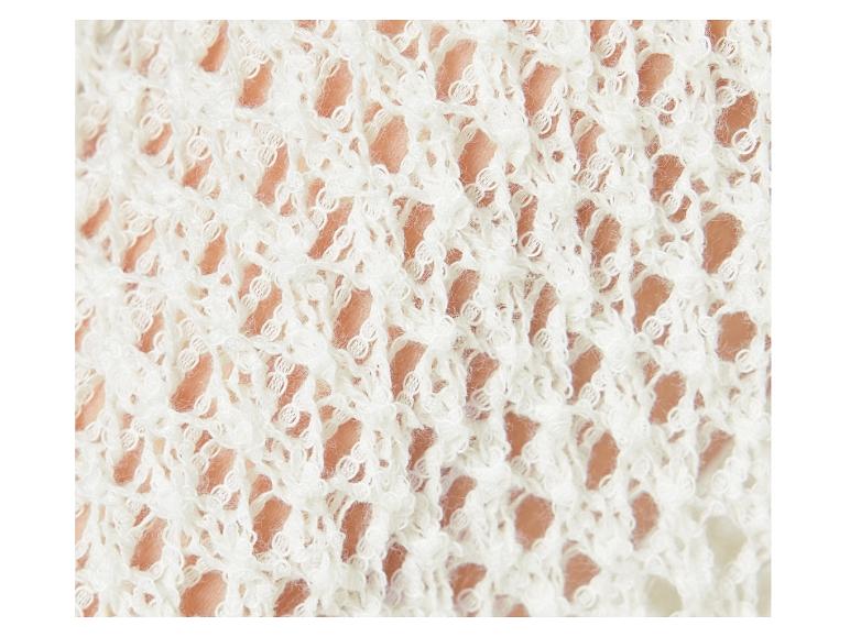 Detail van een wit, opengewerkt gebreid textiel.