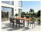 Tuinmeubelset: tafel met houten blad en zes stoelen op een terras.
