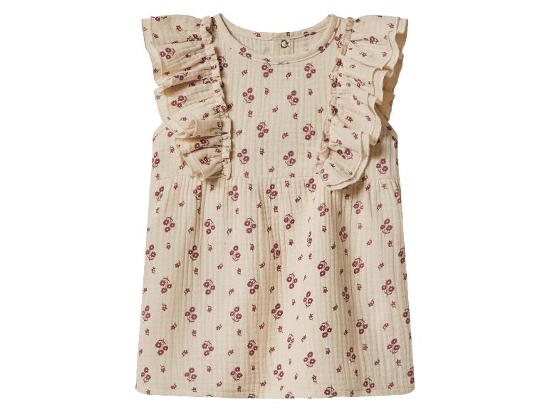Beige babyjurk met rode bloemenprint en ruches op de schouders.