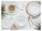 Tafeldekking met wit servies, ontbijtgranen, water en goudkleurig bestek.