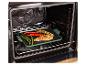 Gegrilde groenten en vlees op een groene grillplaat in een oven.