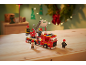 Speelgoedbrandweerauto met brandweerfiguren op een houten tafel.