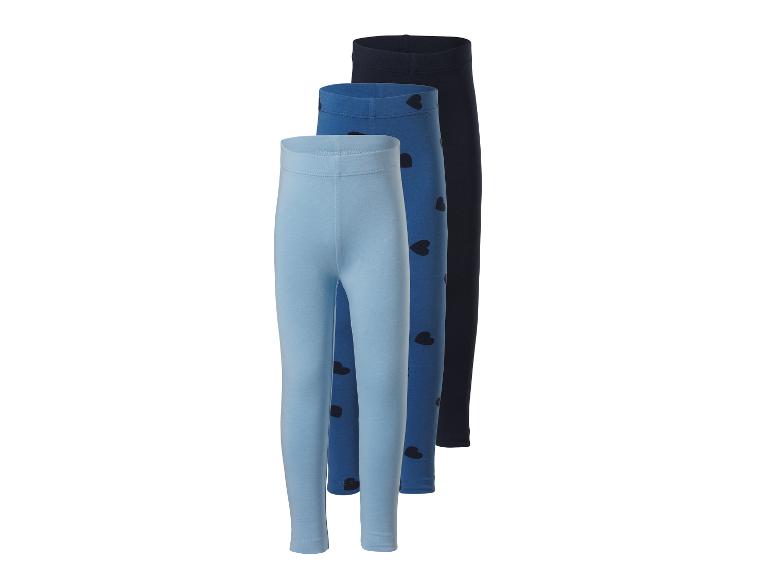 Drie meisjesleggings in blauwtinten, één met hartjes, op een witte achtergrond.