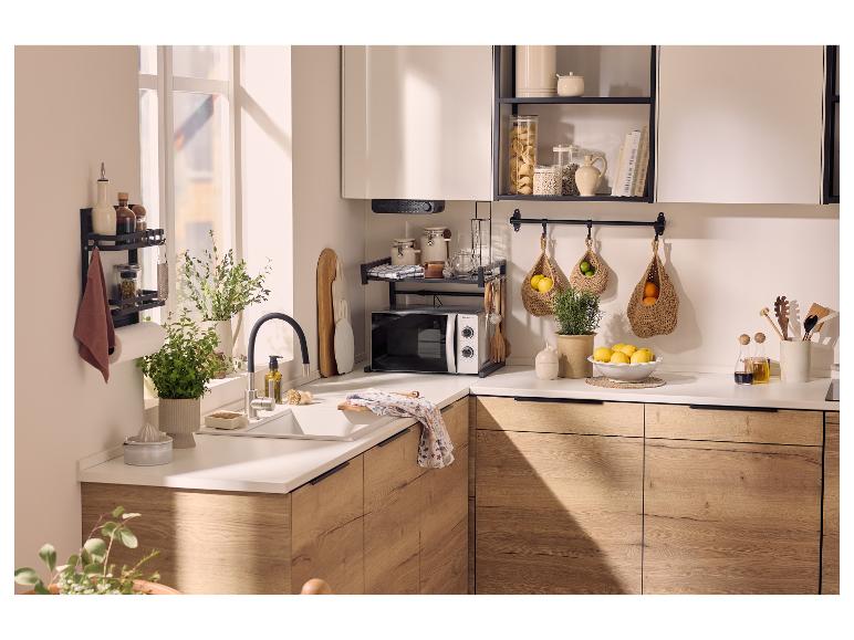 Moderne keuken met houten kasten, wit aanrechtblad, magnetron en open planken.