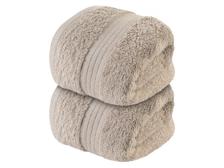 Twee zachte, beige handdoeken, opgevouwen.