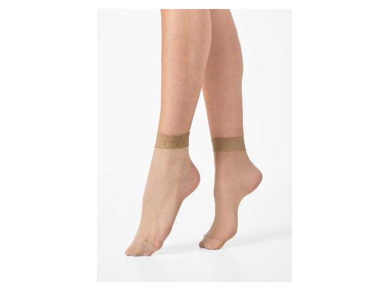 Vrouwenbenen met korte, transparante, huidkleurige sokken.