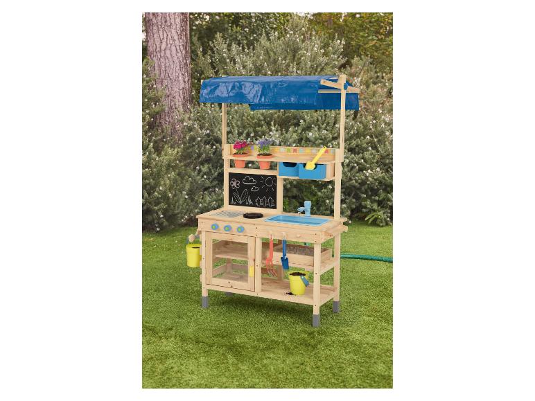 Houten buitenkeuken met blauw zeildoek dak, krijtbord, gootsteen en tuingereedschap.