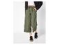 Groene culottebroek met trekkoord, witte top en zwart jack.