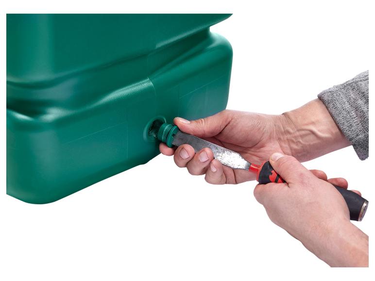 Handen installeren een groene plastic buis in een opvangtank met een gereedschap.