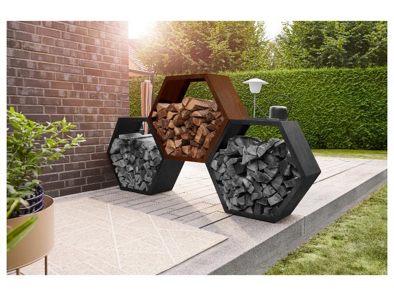 Zeshoekig houtrek op een terras met een bakstenen muur en groene heg.