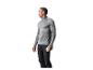 Man in een grijs sportshirt met lange mouwen en zwarte broek, met een waterfles.
