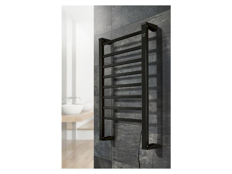 Zwarte handdoekradiator gemonteerd op een donkere tegelmuur in een badkamer.