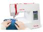 Witte en rode naaimachine met digitaal display, naait blauwe stof.