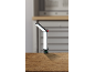 Verstelbare LED-werklamp met klem op een houten oppervlak in een werkplaatsomgeving.