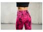 Vrouw draagt roze leggings met zwart geometrisch patroon.