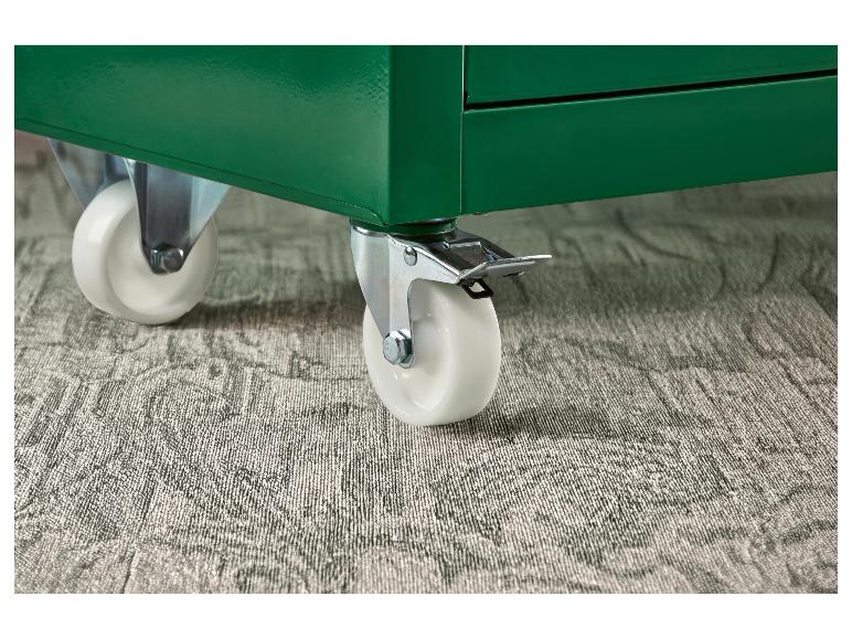 Witte wielen op een groene opbergunit, op een grijs tapijt