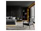 Moderne donkere slaapkamer met bed, fauteuil en boekenkast met decoratieve verlichting.