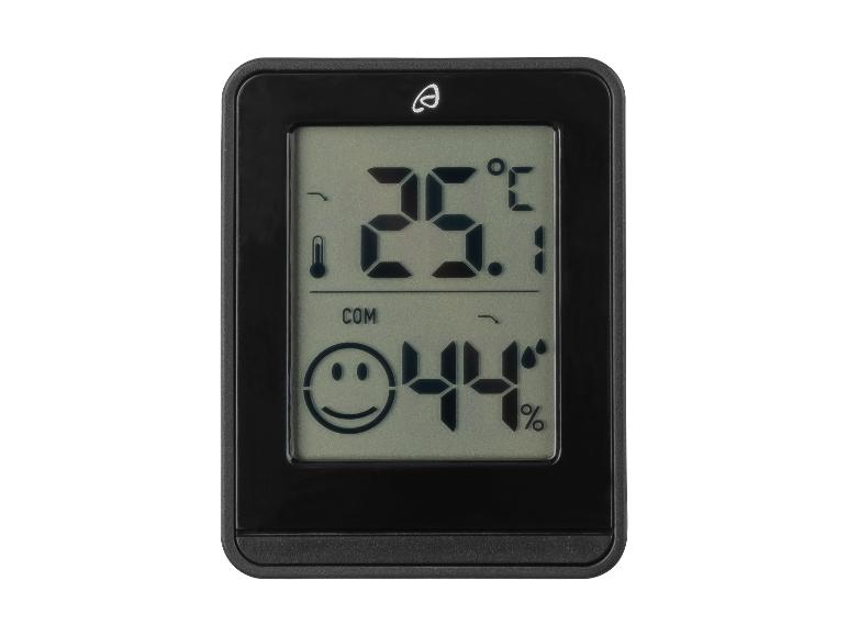 Een digitale thermometer en hygrometer met een glimlach, die 23.1 graden Celsius en 44% luchtvochtigheid weergeeft.