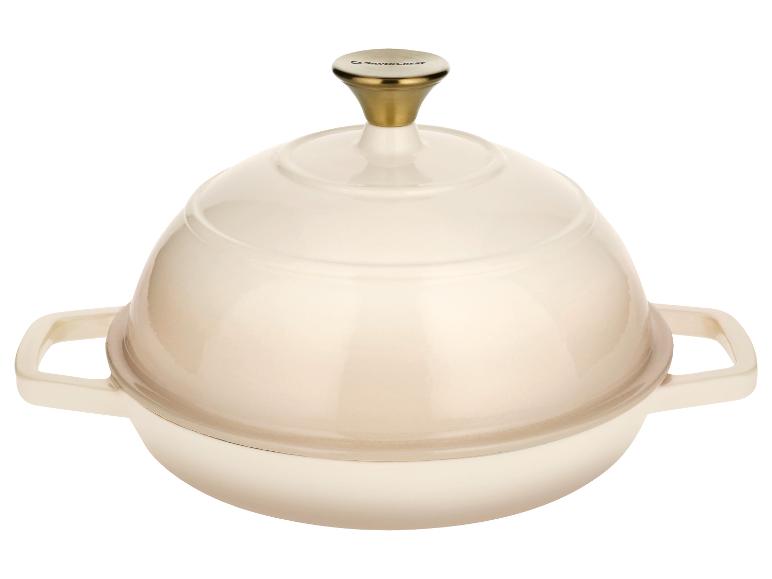 Crèmewitte gietijzeren pan met een gouden knop op het deksel