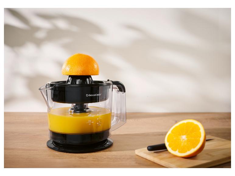 Silvercrest citruspers met sinaasappels en sap op een houten aanrecht.