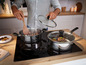 Twee Tefal-pannen met glazen deksels op een inductiekookplaat.