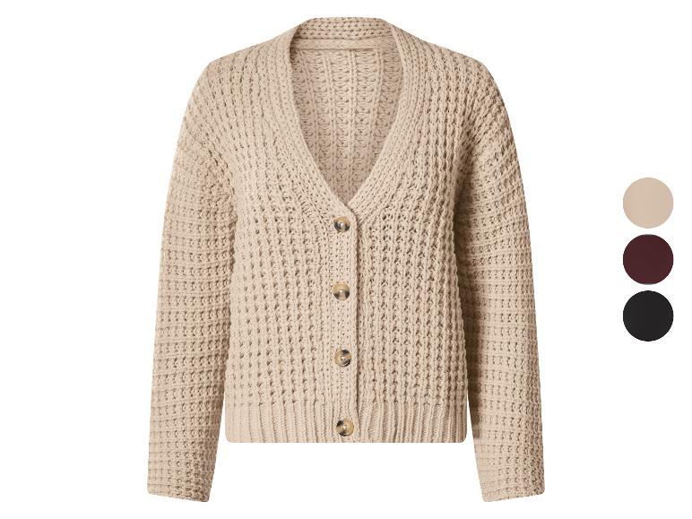 Beige gebreid vest met knopen en een kleurenpalet aan de zijkant.
