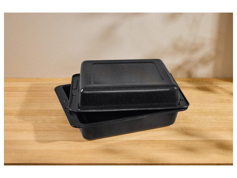 Twee zwarte braadsledes met deksels, gestapeld op een houten tafel.