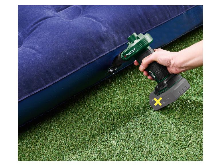 Elektrische luchtpomp blaast een blauw opblaasbaar matras op groen gras op.