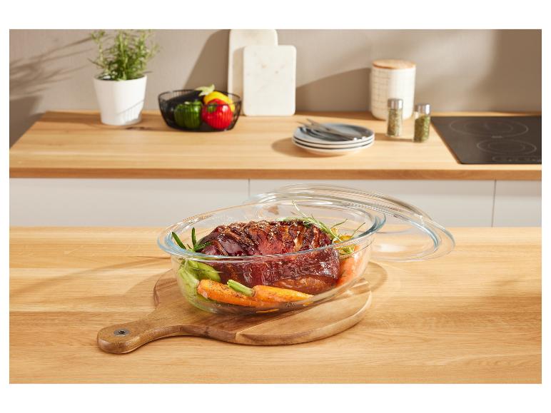 Gebraden vlees in een glazen schaal op een houten plank.