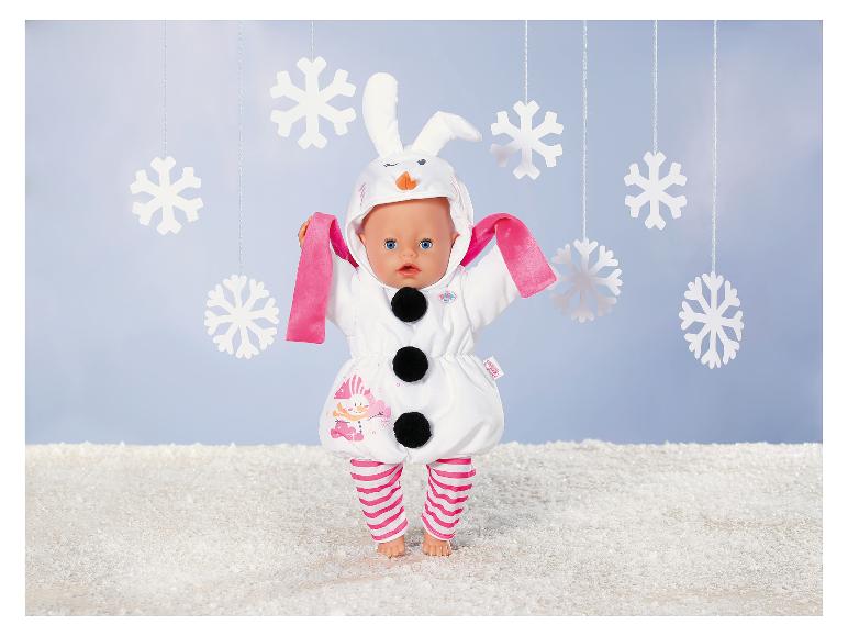 BABY born pop in sneeuwmanpak met konijnenoren, omringd door sneeuwvlokken.