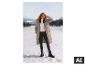 Vrouw in een witte ESMARA® gebreide trui en winterjas in de sneeuw. [AI-gegenereerde afbeelding]