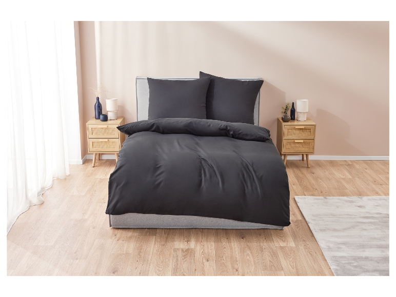 Zwarte beddengoed op een grijs bed in een modern ingerichte slaapkamer.