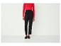 Zwarte broek met een rood shirt en zwarte loafers met kwastjes.