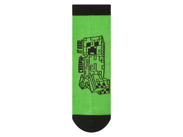 Groene sok met zwart pixelmonsterontwerp en de tekst 'CREEPIN' IT REAL'.