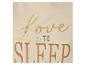 Close-up van een crèmekleurige top met goud- en bruine opdruk met de tekst 'Love to Sleep'.