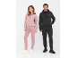 Man en vrouw in hoodies met rits en joggingbroek, vrouw in roze, man in zwart.