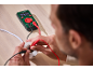 Een man gebruikt een Parkside multimeter voor elektrische metingen.