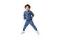 Jongen in blauw trainingspak met NYC-opdruk springt lachend.