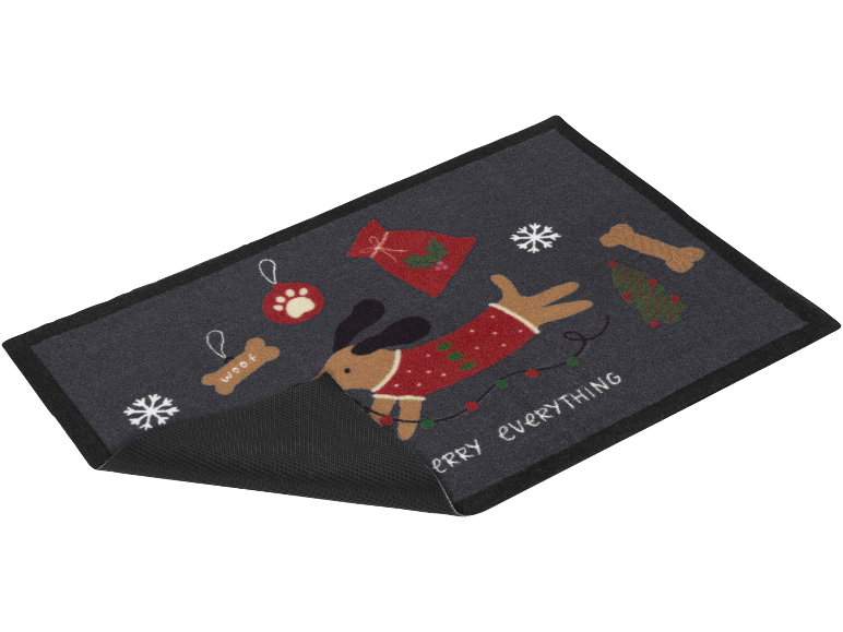 Kerstdeurmat met een hond in een trui, sneeuwvlokken en de tekst 'MERRY EVERYTHING'.